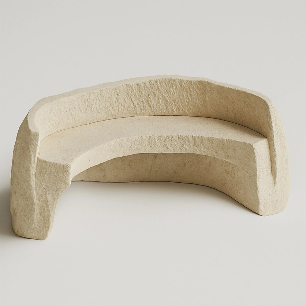 Arco travertine bench by Andres Monnier with a curved seat, integrated backrest and rough texture.