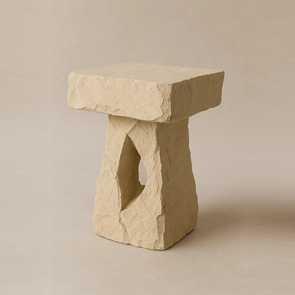 Breccia travertine side table by Andres Monnier with a rough rectangular form and central opening.