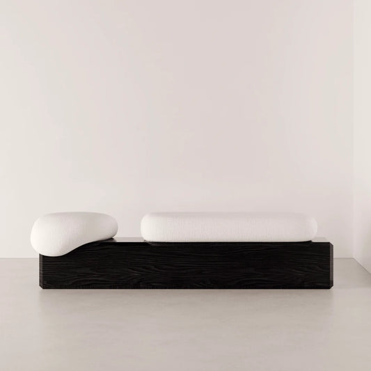 Front view of the Winter Bench by Antony Gasnier with two rounded white cushions on a dark solid oak base