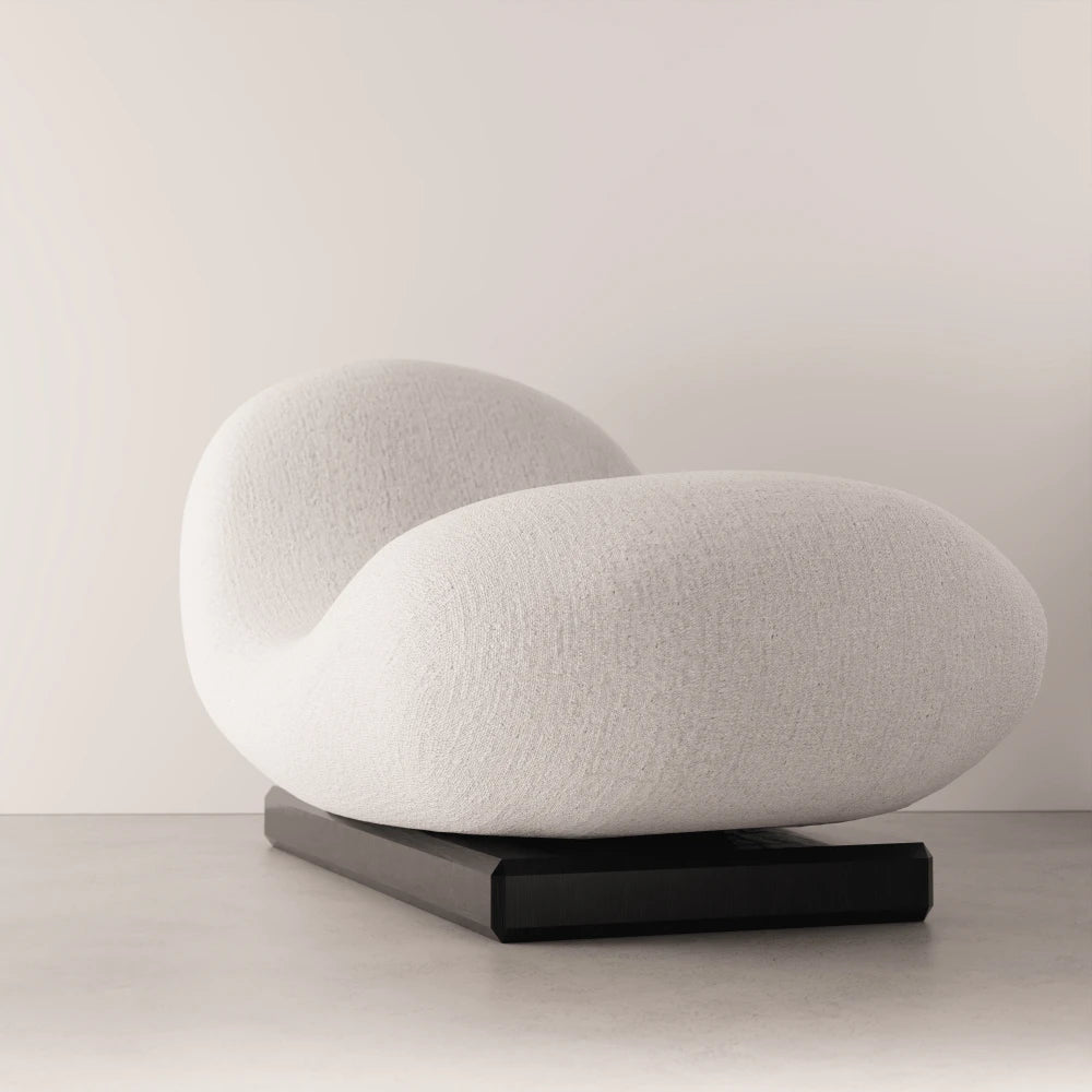 Three-quarter view of the Winter Daybed by Antony Gasnier, showing its sculpted white upholstery and dark oak base