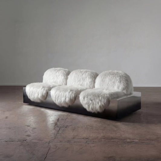 Three-quarter view of the Sans Poids sofa by Diamant Versatile, featuring three white long-haired upholstered seats on a metal base.