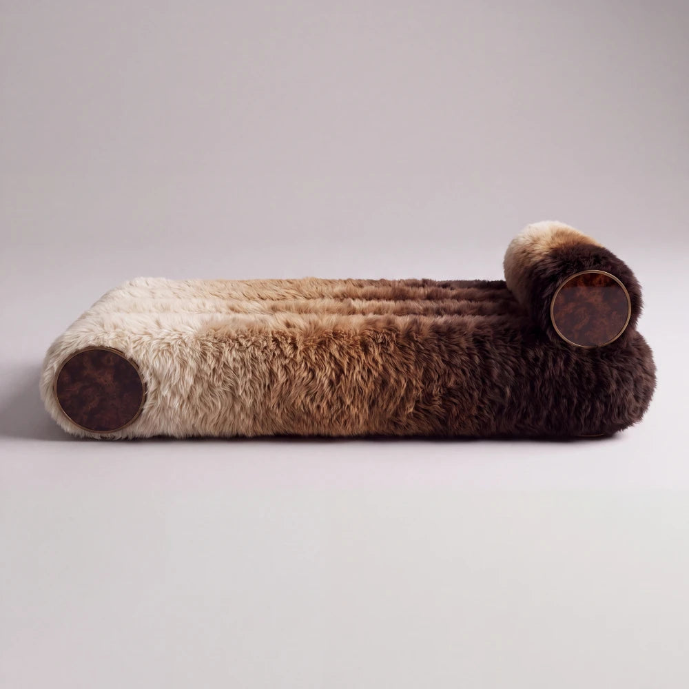 Side view of the Sediment daybed by Diamant Versatile, featuring gradient fur upholstery, cylindrical bolsters and circular wood end details.