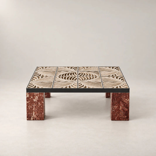 Front view of the Hikari Coffee Table by Eva Szumilas, showing its patterned beige stone top within a dark frame above red marble legs.