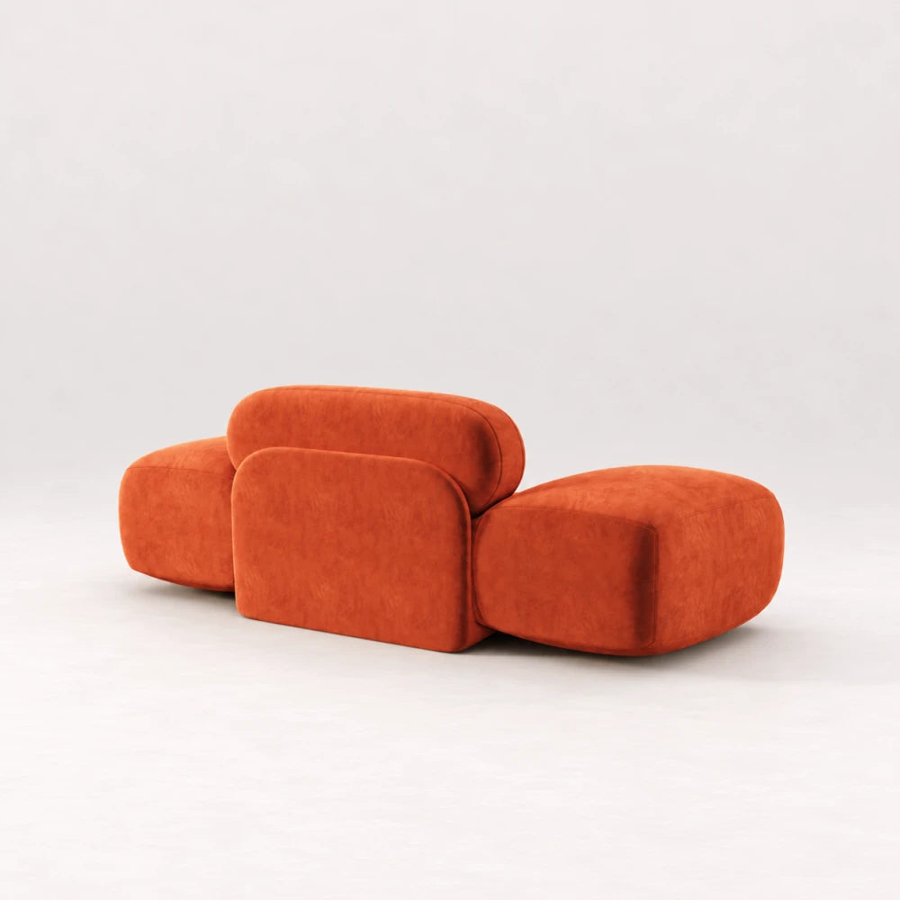 Rear view of the Infinity Armchair 02 by Eva Szumilas in orange upholstery, showing its rounded central support panel and broad curved arms.