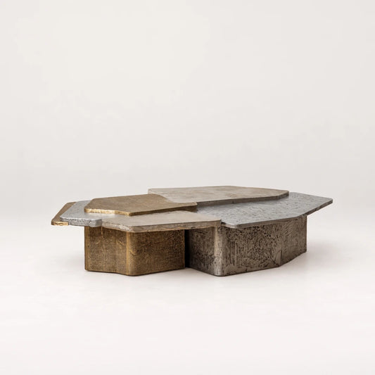 Angled view of the Scorpio 170 Coffee Table by Eva Szumilas, showing layered geometric surfaces and contrasting gold-toned and silver-toned textured bases.