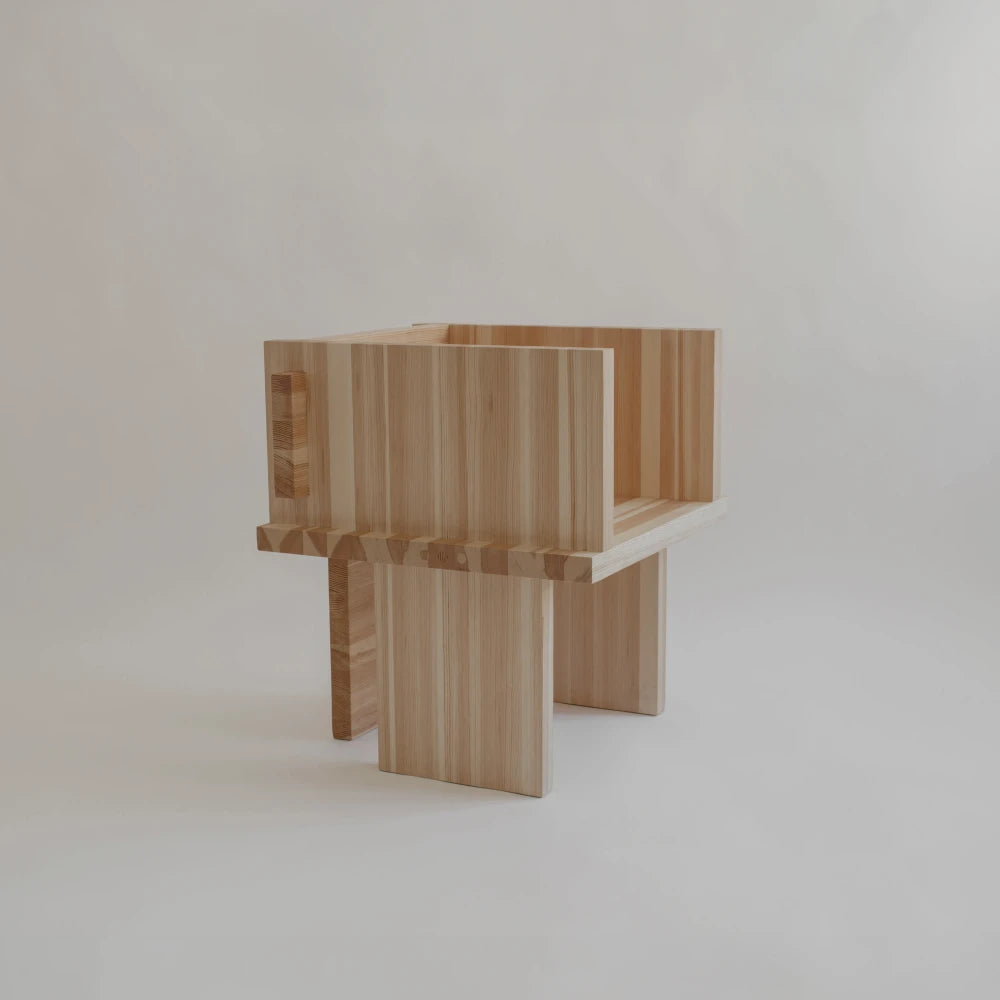 Three-quarter view of the Itooraba Chair by Sizar Alexis, featuring solid Swedish pine panels, broad armrests and geometric slab legs.