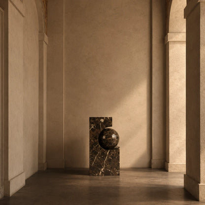 AM-01 pedestal in Emperador and dark marble by AMARE EDITIONS, styled in a warm architectural interior