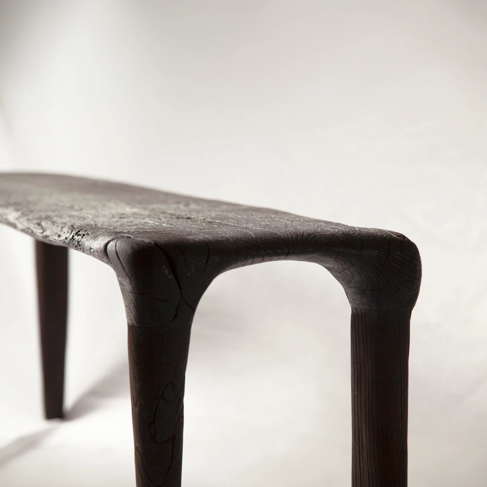 Close-up of a rounded corner of the Eclipse console, showing the grain and cracks of the charred reclaimed oak