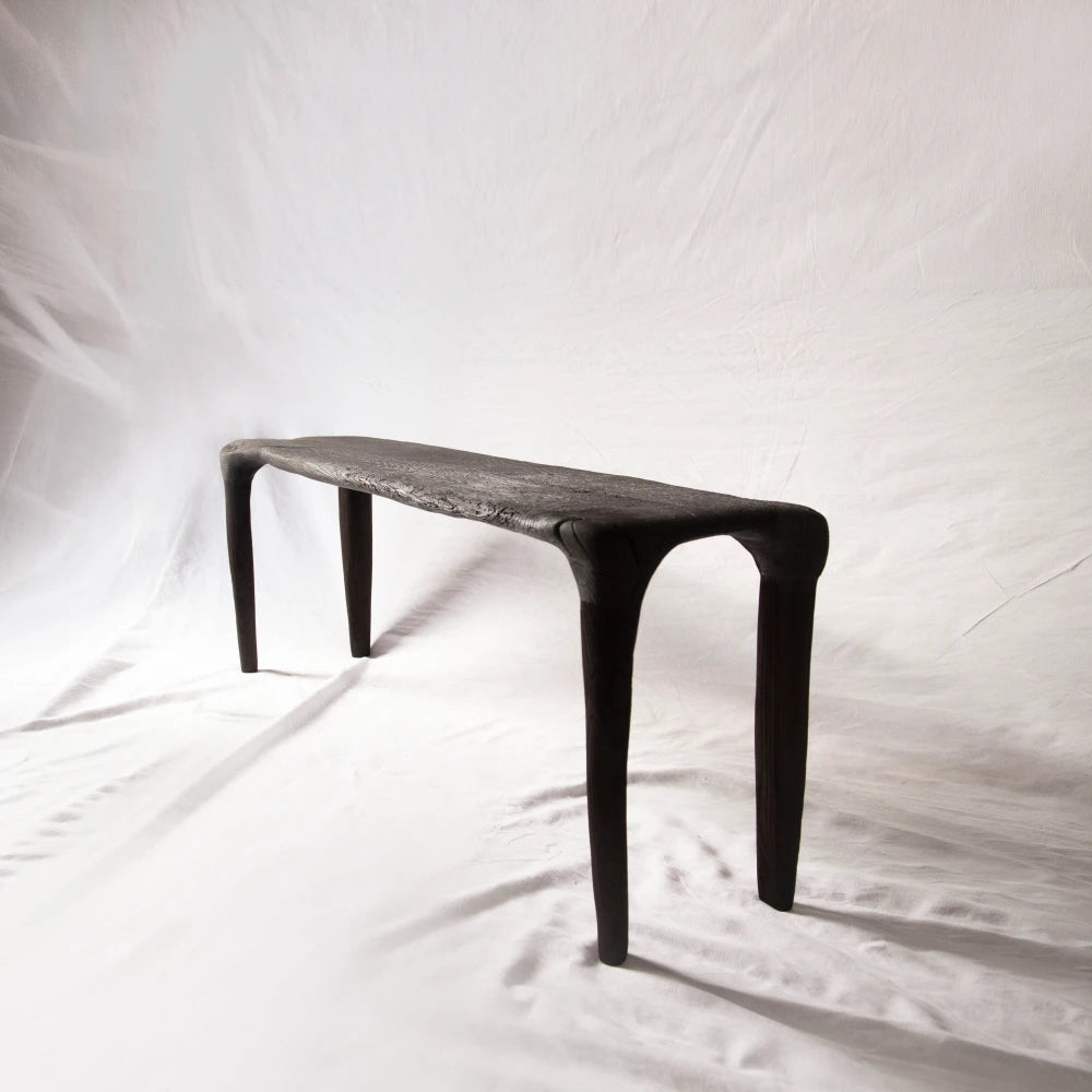 Eclipse console in hand-carved and charred reclaimed oak by Antoine Maurice, shown with its four tapered legs