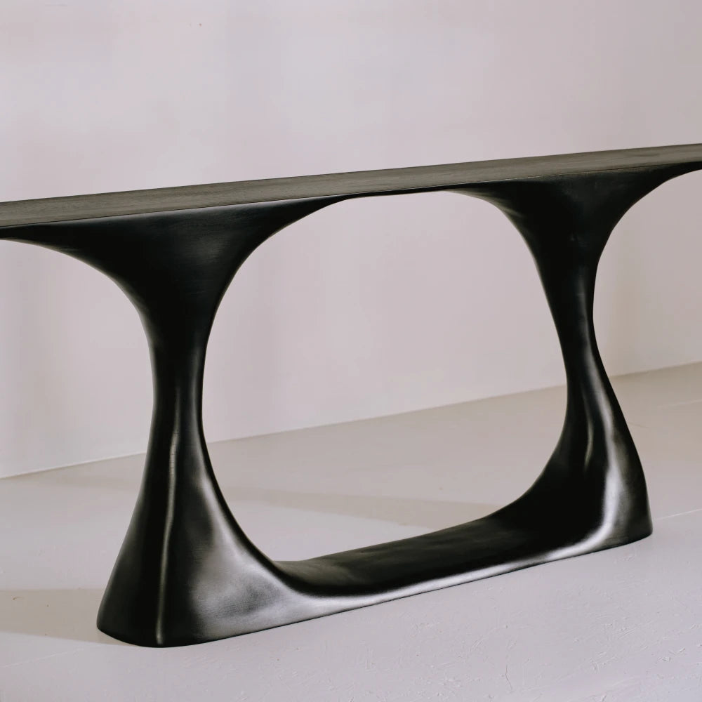 Three-quarter view of the Invitation console, highlighting its curved supports and sculptural open beech base