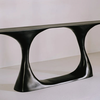 Three-quarter view of the Invitation console, highlighting its curved supports and sculptural open beech base