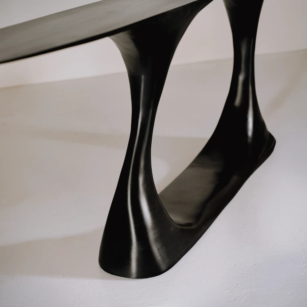 Close-up of the glossy hand-carved beech base and inner curve of the Invitation console