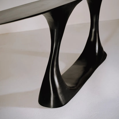 Close-up of the glossy hand-carved beech base and inner curve of the Invitation console