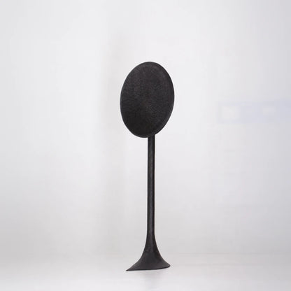 Three-quarter front view of the Solis floor lamp by Antoine Maurice, showing its textured oval disc and flared base