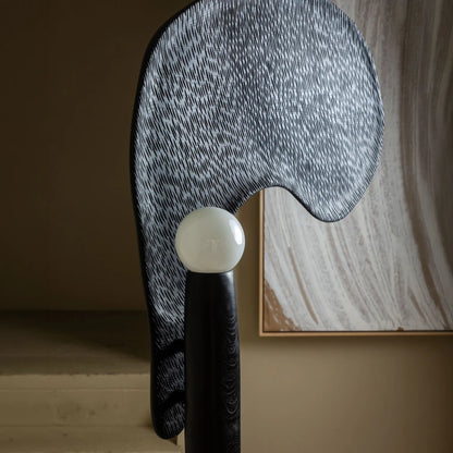 Close-up side view of the Spectre floor lamp, showing its spherical light set within the textured curved oak form