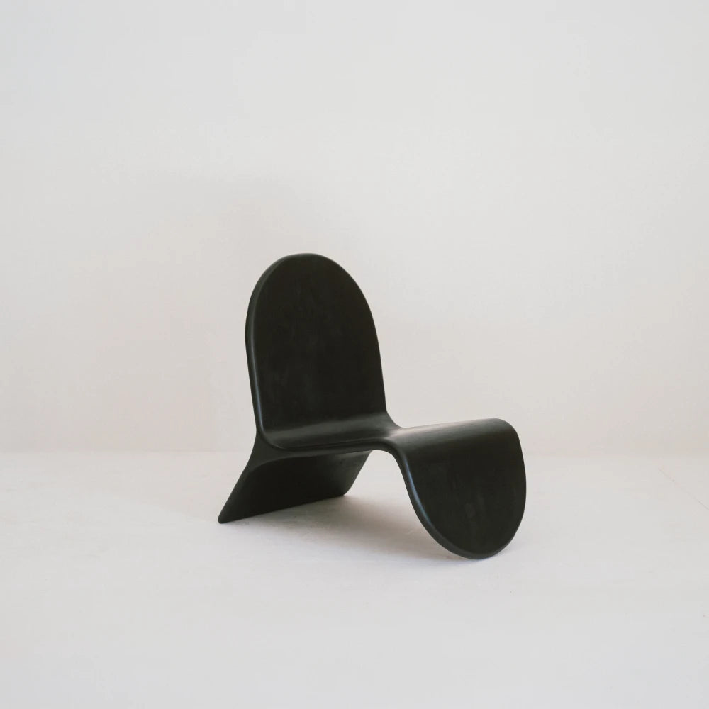 Alma chair in high-gloss black beech by Antoine Maurice, front three-quarter view showing its continuous curved profile