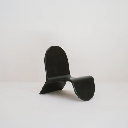 Alma chair in high-gloss black beech by Antoine Maurice, front three-quarter view showing its continuous curved profile