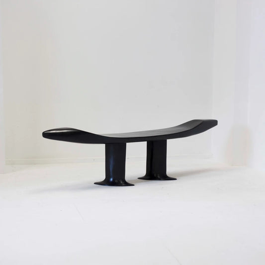 Orphée bench in high-gloss black carved beech by Antoine Maurice, showing its curved seat and raised ends