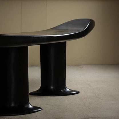 Close-up of the Orphée bench by Antoine Maurice, highlighting its flared legs and high-gloss carved beech finish