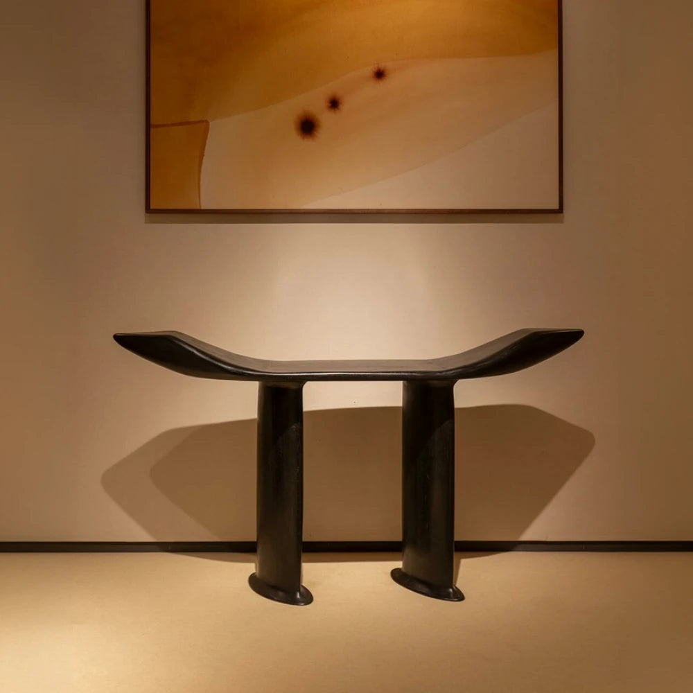 Front view of the Orphée console by Antoine Maurice in a warmly lit interior, highlighting its curved top and flared legs