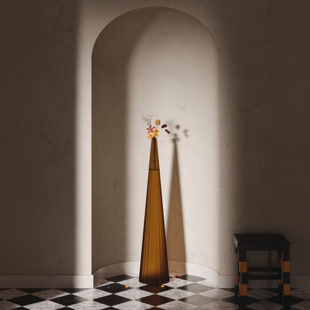 Tall amber Alta Vase by Antony Gasnier with a floral arrangement, displayed beneath an architectural arch
