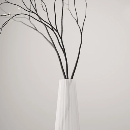 Close-up of the fluted frosted white Alta Vase by Antony Gasnier holding tall dark branches