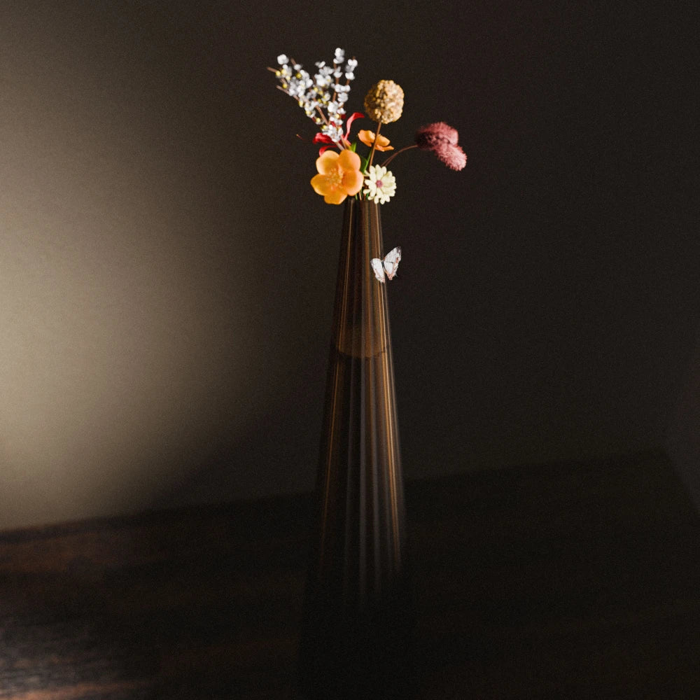 Amber Alta Vase by Antony Gasnier with colourful flowers and a decorative butterfly against a dark background