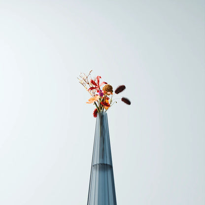 Close-up of a tall blue-grey Alta Vase by Antony Gasnier with a colourful floral arrangement