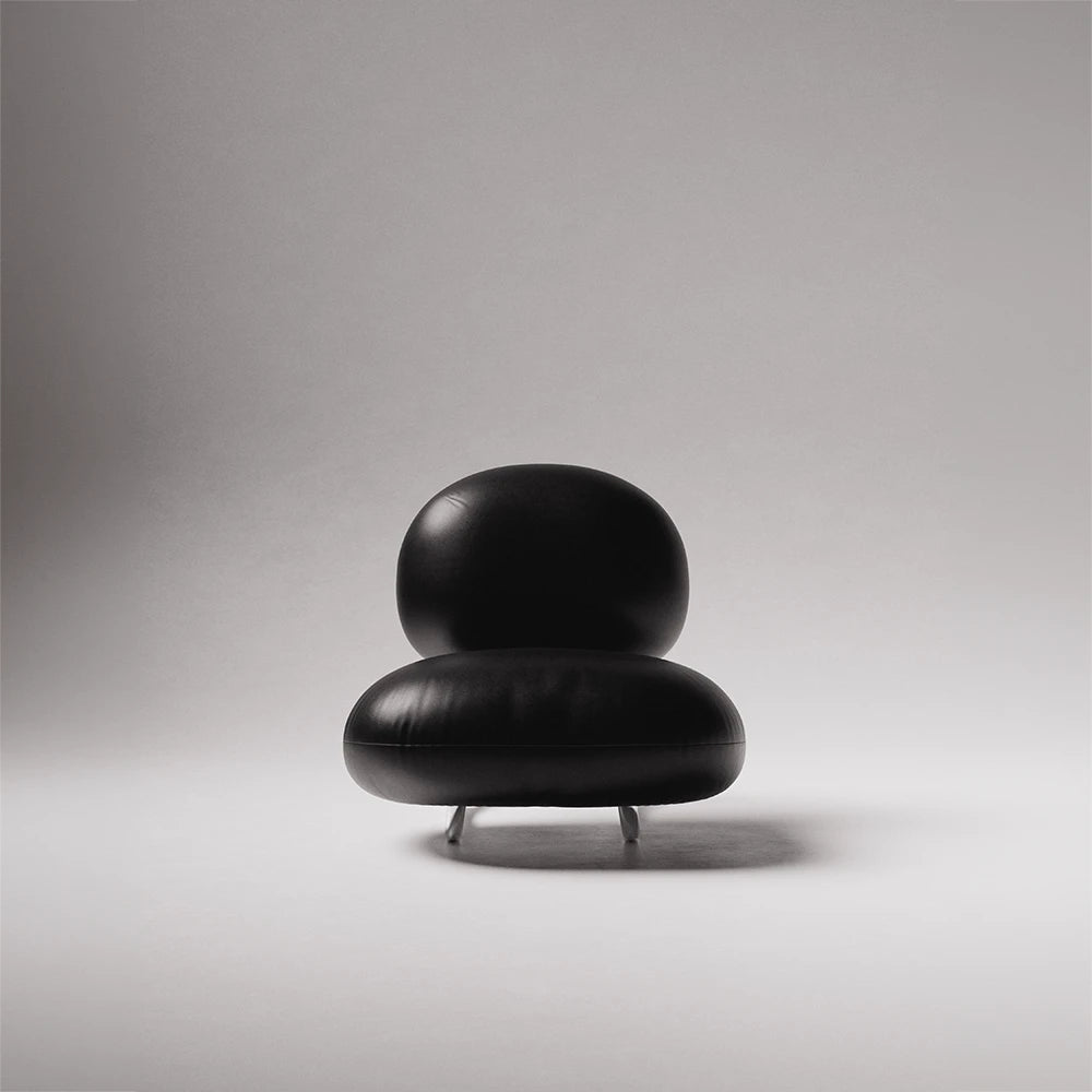 Front view of the C8 Armchair by Antony Gasnier with rounded black leather seat and back cushions