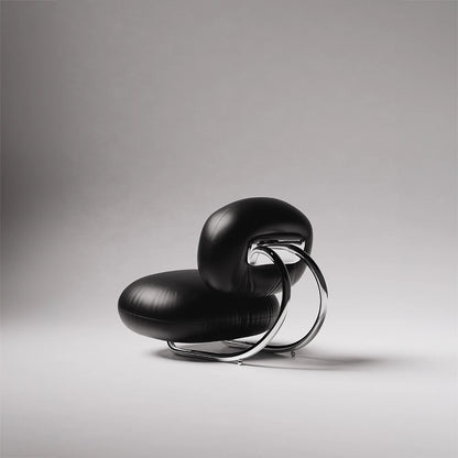 Rear three-quarter view of the C8 Armchair by Antony Gasnier, highlighting its curved chrome frame and rounded leather cushions