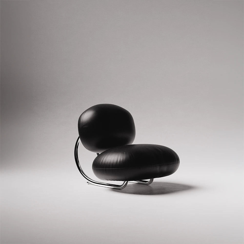 Three-quarter view of the C8 Armchair by Antony Gasnier, showing its generous black leather seat and curved metal frame