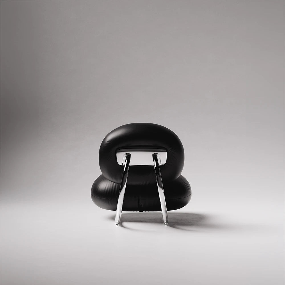 Rear view of the C8 Armchair by Antony Gasnier with a rounded leather backrest and polished chrome supports