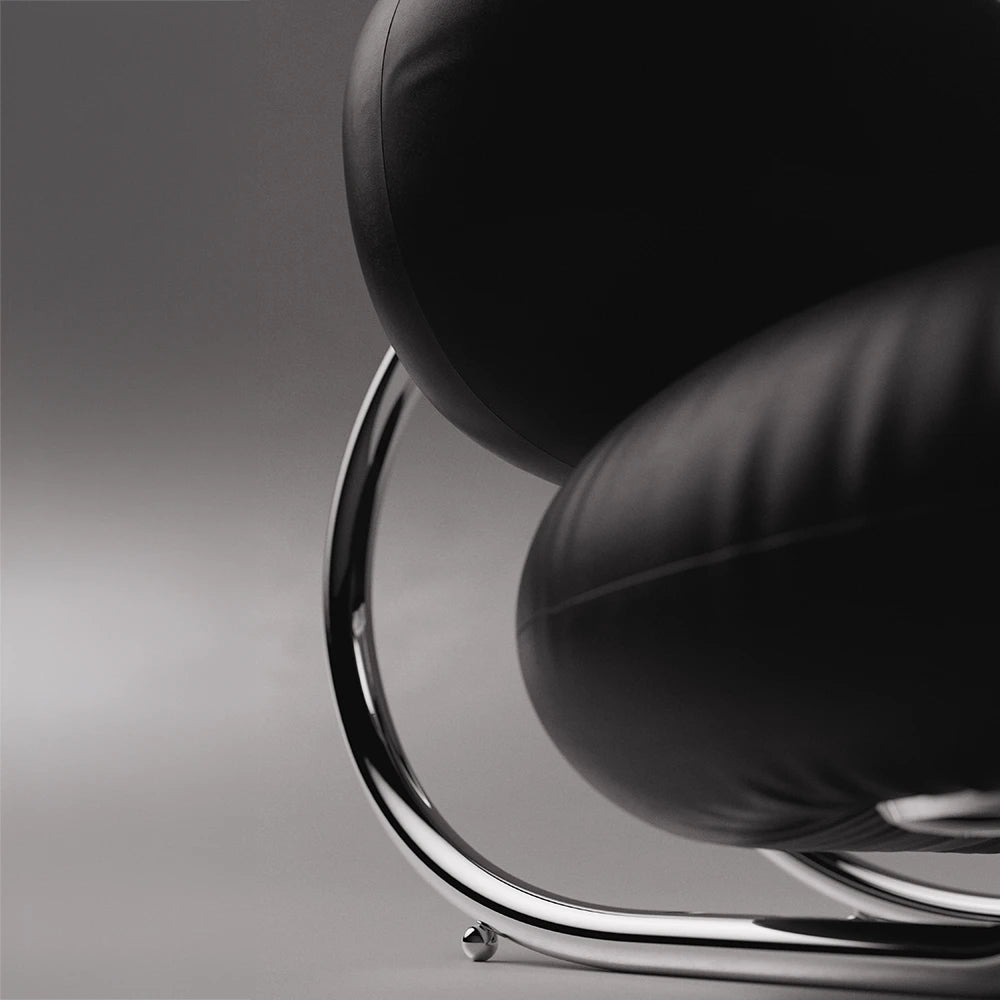 Close-up of the black leather cushions and polished curved frame of the C8 Armchair by Antony Gasnier