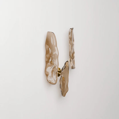 Three-quarter view of Antony Gasnier’s Pinaster wall lamp, showing its layered glass forms and discreet brass mounting.