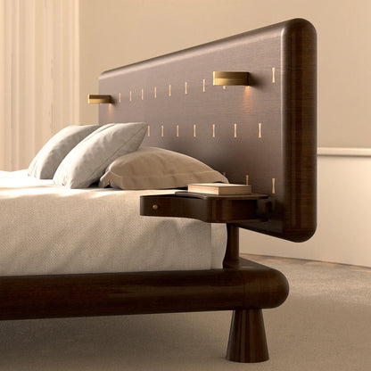 Side detail of the Will Bed by Antony Gasnier showing its rounded wood frame, headboard, reading light and integrated table