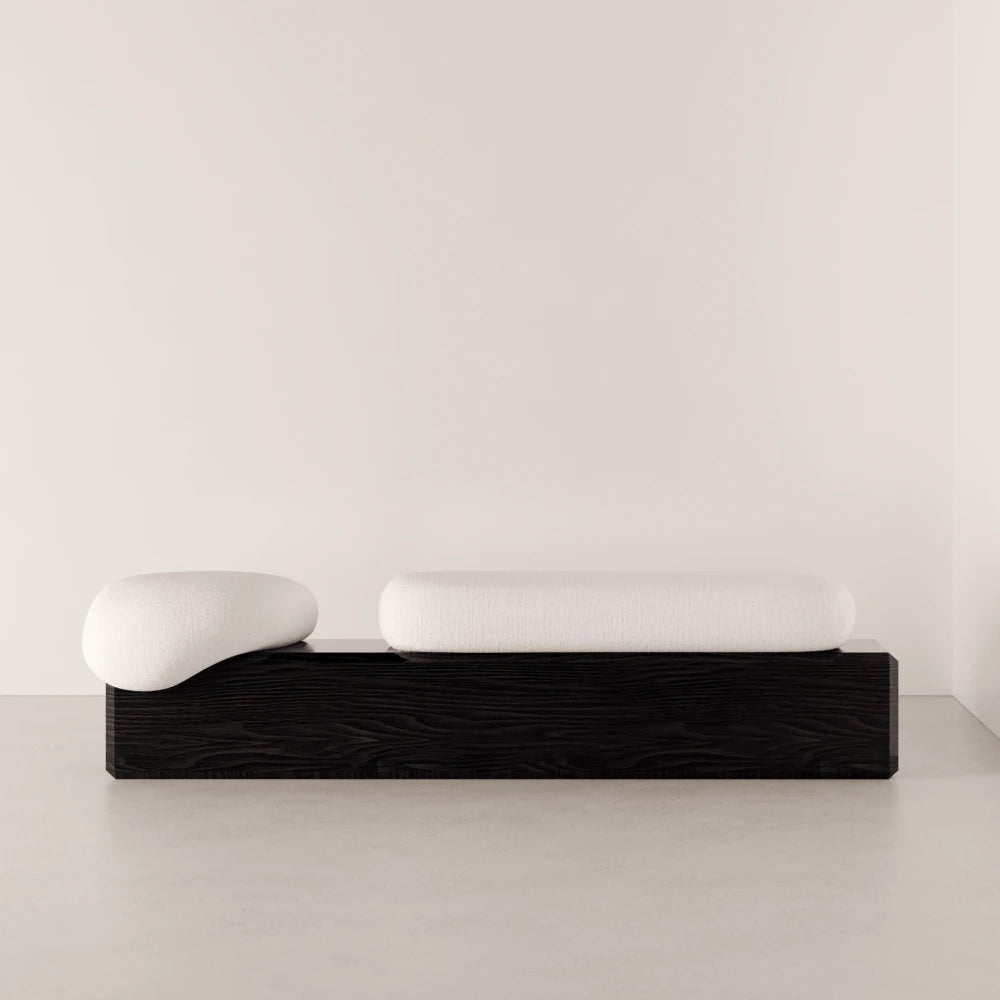Front view of the Winter Bench by Antony Gasnier with two rounded white cushions on a dark solid oak base