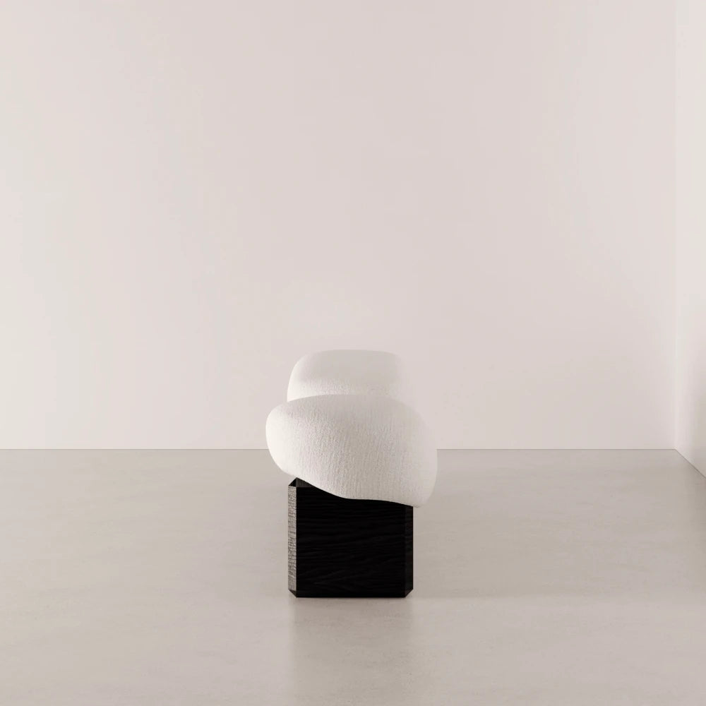 Side view of the Winter Bench by Antony Gasnier, highlighting its curved upholstered cushions and dark oak base