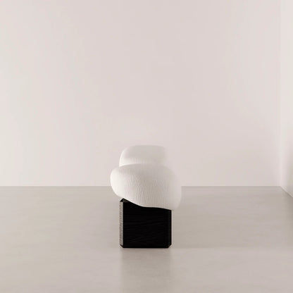 Side view of the Winter Bench by Antony Gasnier, highlighting its curved upholstered cushions and dark oak base