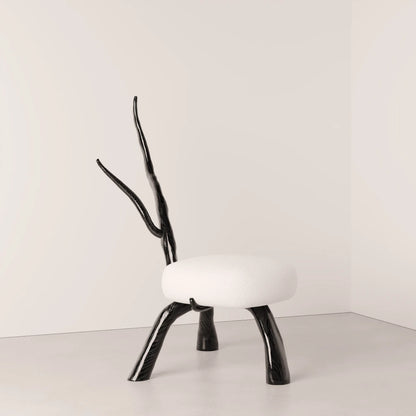 Three-quarter view of the Winter Branch Chair by Antony Gasnier, showing its sculptural oak legs and rounded white seat