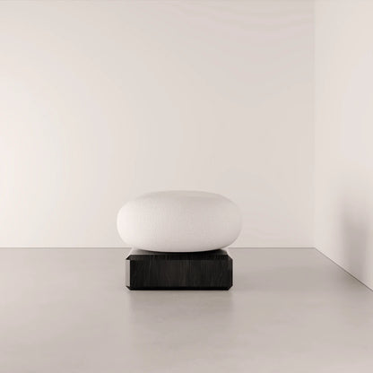 Front view of the Winter Ottoman by Antony Gasnier with a rounded white fabric seat and rectangular dark oak base