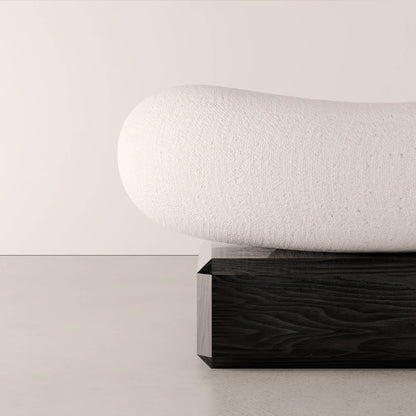 Close-up of the textured white upholstery and dark solid oak base of the Winter Ottoman by Antony Gasnier