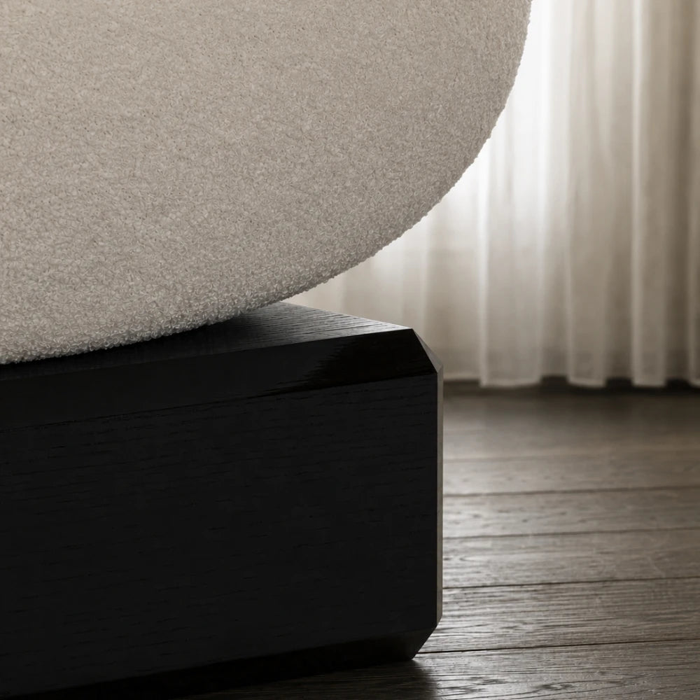 Close-up of the Winter Ottoman by Antony Gasnier, showing its textured white seat resting on a dark solid oak base