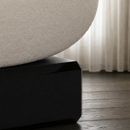 Close-up of the Winter Ottoman by Antony Gasnier, showing its textured white seat resting on a dark solid oak base
