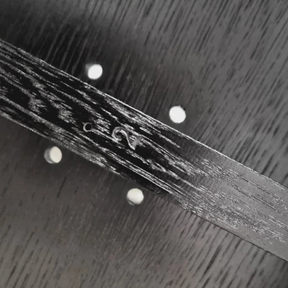 Close-up of the maker’s signature on the dark solid oak structure of the Winter Ottoman by Antony Gasnier