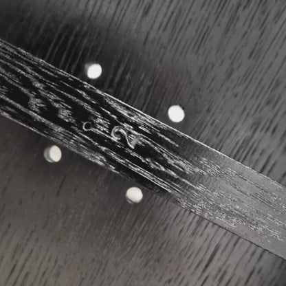 Close-up of the maker’s signature on the dark solid oak structure of the Winter Ottoman by Antony Gasnier