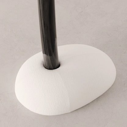 Close-up of the rounded white upholstered base and dark wood trunk of the Winter Tree coat stand by Antony Gasnier