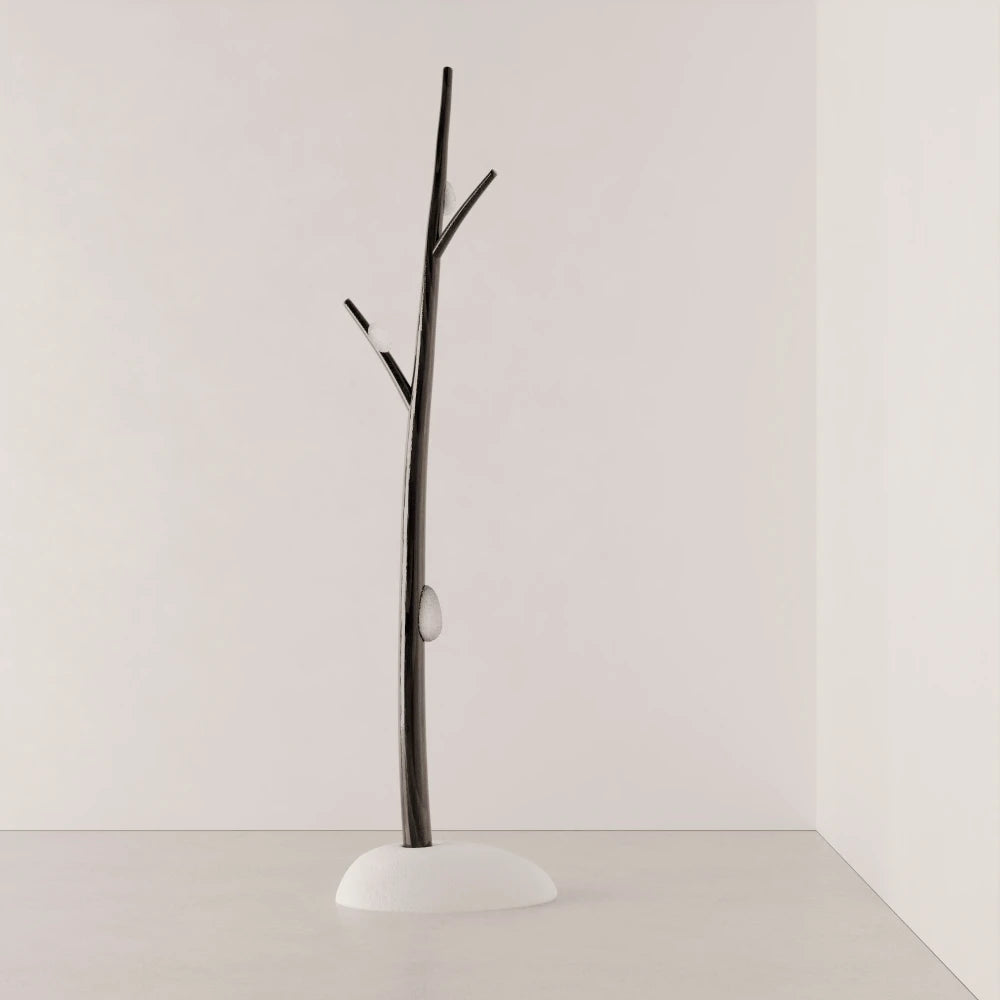 Full view of Antony Gasnier’s Winter Tree Light floor lamp, with a dark wood trunk, branch-like arms and white upholstered base.