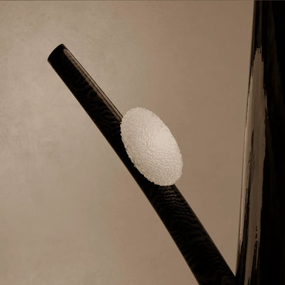 Illuminated detail of the textured glass diffuser on Antony Gasnier’s dark wood Winter Tree Light floor lamp.
