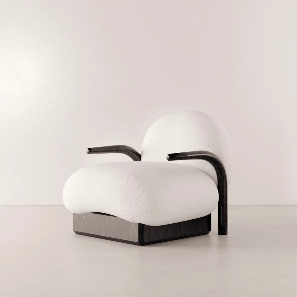 Winter Armchair in solid oak and white fabric by Antony Gasnier, three-quarter view showing its curved armrests and generous seat