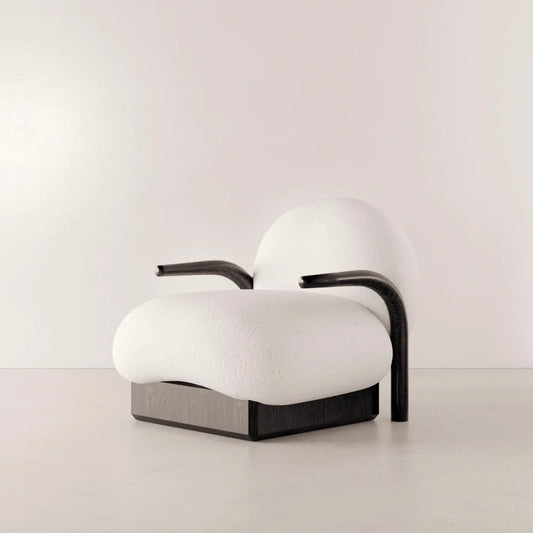 Winter Armchair in solid oak and white fabric by Antony Gasnier, three-quarter view showing its curved armrests and generous seat
